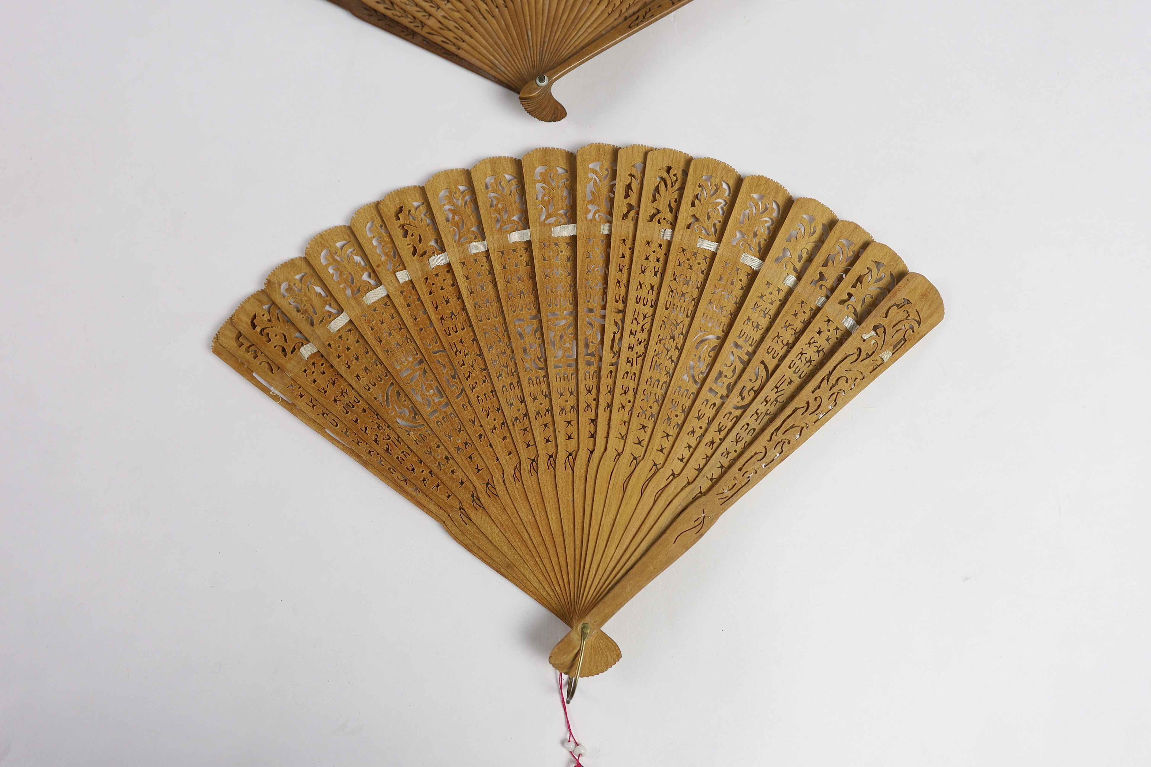 A 19th century Chinese sandalwood brisé fan and a smaller 20th century Chinese sandalwood fan